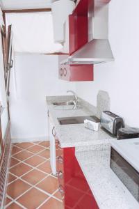 una cocina con armarios rojos y fregadero en Vivienda Turistica Arabeluj, en Güéjar-Sierra