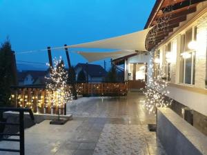 eine Terrasse mit einem Weihnachtsbaum und Licht an einem Gebäude in der Unterkunft Pensiunea Morariu in Bistriţa