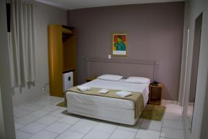 1 dormitorio con 1 cama con 2 toallas en Presidente Hotel, en Passos