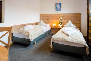 a bedroom with two beds and a wooden wall at Pension Domblick in Wetzlar