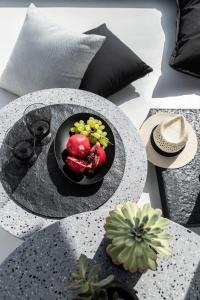 a table with a plate of fruits and vegetables on it at Nimbus Mykonos in Agios Stefanos