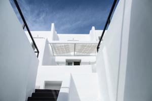 a view from the stairs of a white building at Nimbus Mykonos in Agios Stefanos