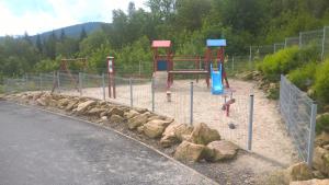 a playground with a slide and rocks in the sand at Apartament pod Czarną Górą in Sienna