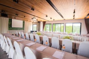 a conference room with a long table and white chairs at Amanta Hotel Nongkhai in Nong Khai