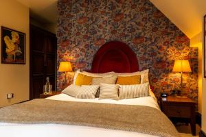 a bedroom with a large bed with floral wallpaper at Fox and Anchor in London