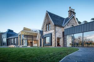 Casa de piedra grande con ventanas grandes de cristal en Isle of Raasay Distillery en Raasay