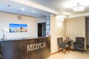 a salon with a reception desk and two chairs at SCSK Brzeźno in Gdańsk