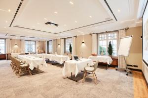 une salle de conférence avec des tables et des chaises blanches dans l'établissement Hotel Gutsgasthof Stangl, à Neufarn