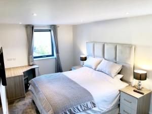 a bedroom with a bed and a desk and a window at Millstream Mews in Bakewell