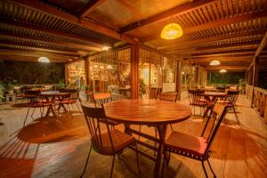 un patio con mesa de madera y sillas en Terrabambu Lodge, en Mindo