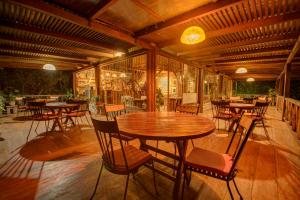 um pátio com uma mesa de madeira e cadeiras em Terrabambu Lodge em Mindo