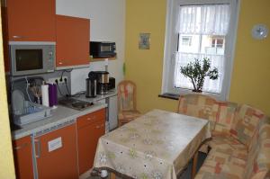 a kitchen with a table and a small kitchen with a table and chairs at Pension Tiffany in Chemnitz