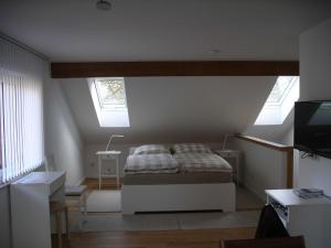 ein Schlafzimmer mit einem Bett und zwei Fenstern in der Unterkunft Ferienhäuschen in Thangelstedt