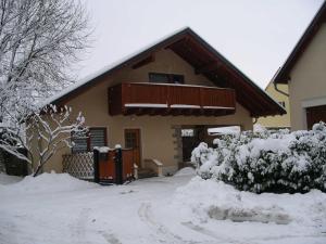 Casa cubierta de nieve con balcón en Ferienhaeuschen, en Thangelstedt