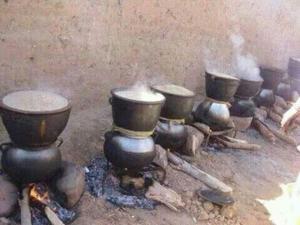 a group of pots and pans sitting over a fire at Amtoudi Aventure in Id AÃ¯ssa