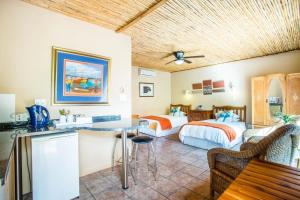 a hotel room with two beds and a table at De Poort Country Lodge in Oudtshoorn
