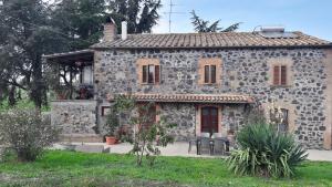 una vieja casa de piedra con una puerta roja en B&B Il Cardellino en Porano