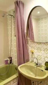 a bathroom with a sink and a mirror and a tub at Explorer Apartment Düsseldorf in Düsseldorf