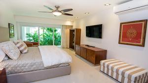 1 dormitorio con 1 cama y TV de pantalla plana en CortesStars, en Cancún