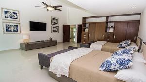 1 dormitorio con 2 camas y TV de pantalla plana en CortesStars, en Cancún