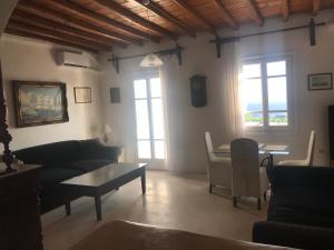 a living room with a couch and a table at Mykonos Beachfront House with Sunset & Delos View in Agios Stefanos