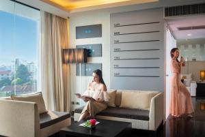 a woman sitting on a couch in a living room at Tsix5 Hotel in Pattaya North