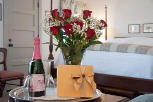 - une table avec un vase de fleurs et une bouteille de champagne dans l'établissement First Colony Inn, à Nags Head