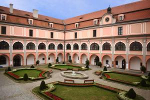 a large building with a courtyard with a fountain at Zámecký Penzion in Valašské Meziříčí