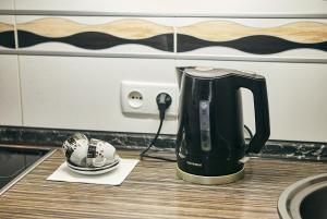 a black coffee maker on a counter next to a helmet at Center Сozy in Vinnytsya