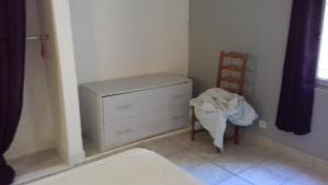 a bedroom with a chair and a dresser and a chair at palayson two in Le Muy