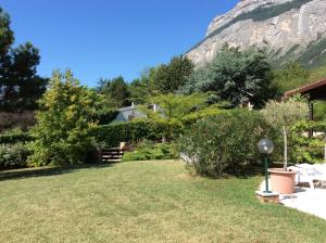 einen Hof mit einem Haus und einem Berg im Hintergrund in der Unterkunft Villa avec vue in Biviers