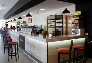 a bar in a restaurant with chairs and a counter at Hotel El Sueño de Jemik in La Roda