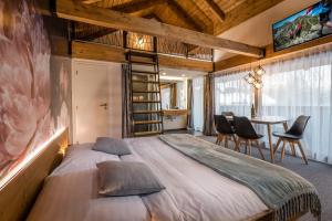 a bedroom with a large bed with chairs and a table at AHA Jasná Apartmány in Liptovský Mikuláš