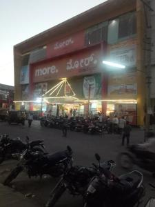 un grupo de motocicletas estacionadas frente a una tienda en hotel sangeeth lodging, en Mysore