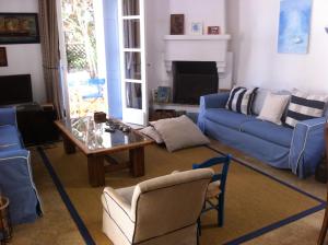 a living room with a blue couch and a table at Villa Pitiousa in Spetses