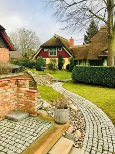 a brick path in front of a red house at "Kajüte 1" by Ferienhaus Strandgut in Born
