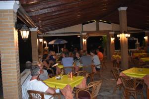 a group of people sitting at tables in a restaurant at Anna Studios in Marathias