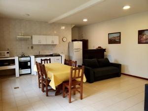 cocina y sala de estar con mesa y sofá en Departamentos Del Bosque en Ushuaia