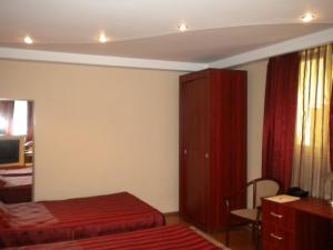 a bedroom with two beds and a red cabinet at Hotel Ary in Cluj-Napoca