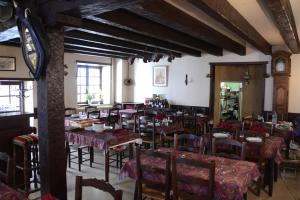 comedor con mesas y sillas y reloj en Auberge de la Poste, en Villefranche-de-Rouergue