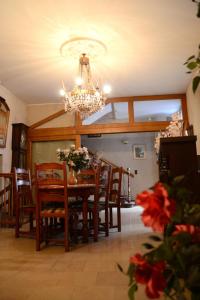 a dining room with a table and chairs and a chandelier at Auberge de la Poste in Villefranche-de-Rouergue