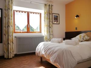 a bedroom with two beds and a window at Le Hameau de Campan in Sainte-Marie-de-Campan