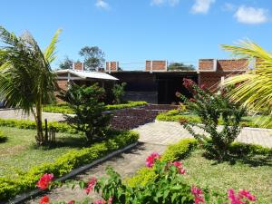 un jardín frente a una casa con flores rosas en Villa-Malaza, en Antalaha
