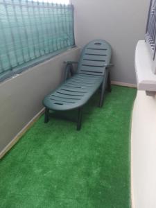 un banco verde sentado en una habitación con alfombra verde en ApartPool El Torreón, en Adeje