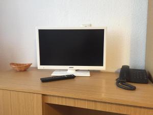 a computer monitor and a phone on a desk at Hotel Deutsches Haus in Kurort Gohrisch