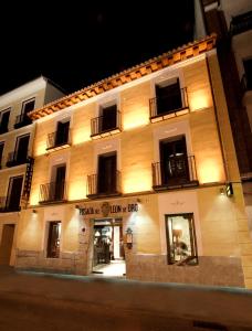 um grande edifício com luzes acesas à noite em Posada del León de Oro Boutique Hotel em Madri