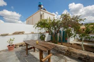 una mesa de picnic de madera en un patio frente a un edificio en Iliopetra Studio en Sívas