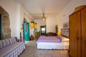 a bedroom with a bed and a couch at Iliopetra Studio in Sívas