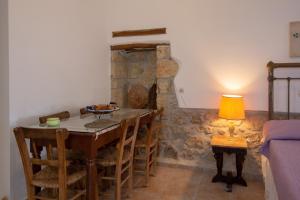 a dining room with a table and chairs and a lamp at Iliopetra Studio in Sívas
