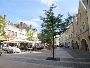 une rue de la ville avec des tables et un arbre au milieu dans l'établissement Bed in Chartres, à Chartres